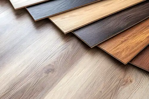 Sho-Me Flooring – Different styles and colors Luxury Vinyl Plank samples laid out on a wood floor in Branson, MO.